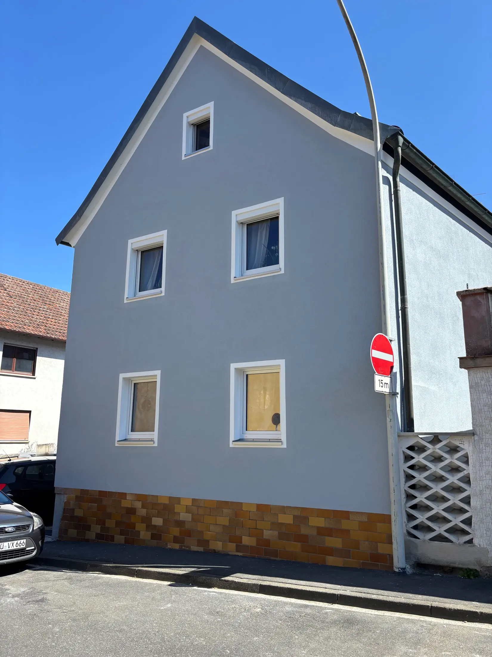 Blaugrau gestrichene Giebelfassade eines Altstadthauses mit weiß abgesetzten Fensterlaibungen